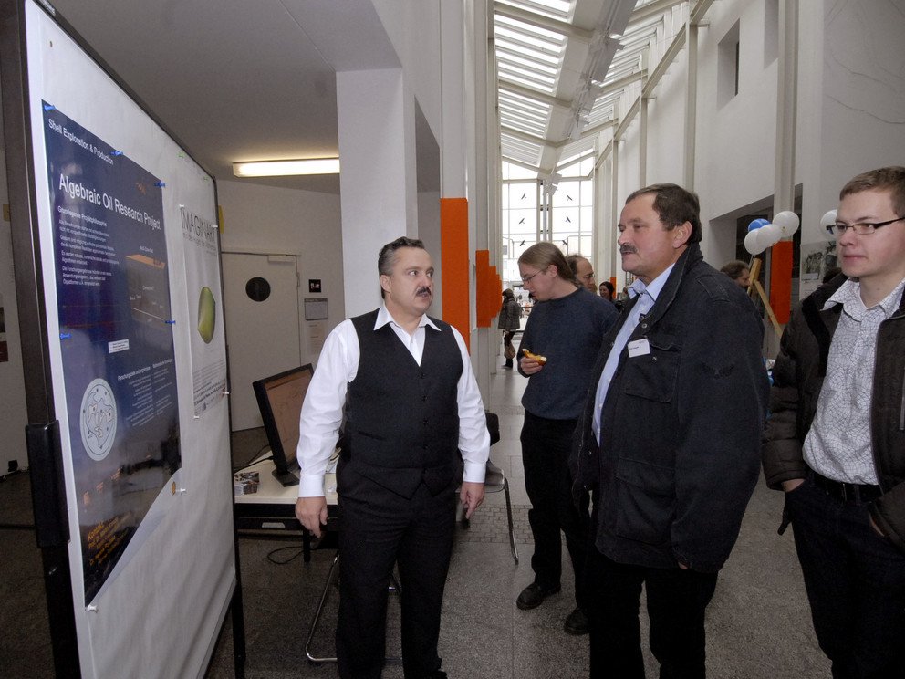 Prof. Kreuzer erkl&auml;rt den Besuchern der Ausstellung das algebraic oil research project